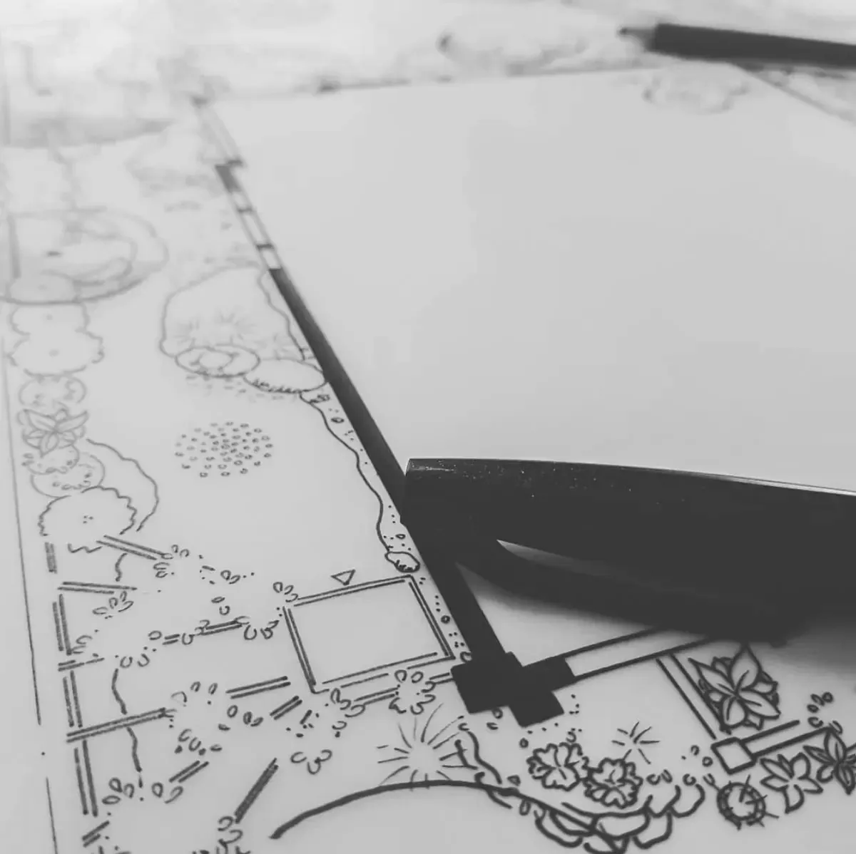 Handgezeichneter Gartenplan in Schwarz-Weiß mit Zeichendreieck und Stift – Entwurfsarbeit am Zeichentisch.