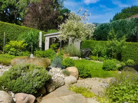 Kiesgarten mit Findlingen, Wasserstein und Gartenhaus