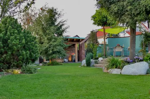 Gartenüberblick mit Findlingen und einer türkisfarbenen Sitzecke
