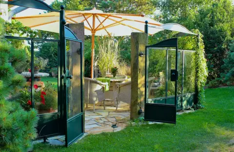 Terrasse und Rasen im warmen Abendlicht mit Staudenbeet