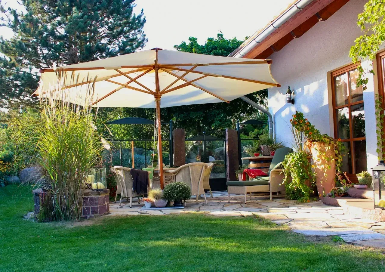 Gemütlicher Terrassensessel mit bepflanztem Kübel im Abendlicht