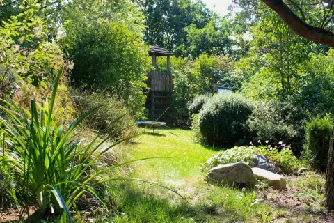 Gartenvista mit Rasenweg und Pavillon zwischen Beeten