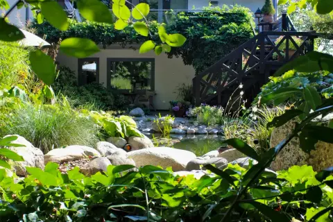 Gartenteich mit Findlingen und üppiger Bepflanzung