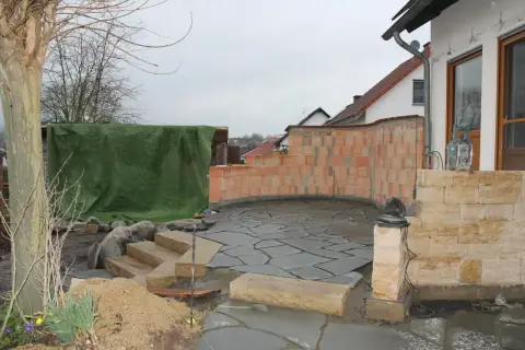 Bauphase: Verlegen eines Natursteinbelags an der Terrasse