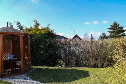 Ausgangssituation: hölzerner Gartenpavillon mit Sitzplatz an einer Hecke