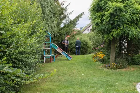 Ausgangssituation: weitläufige Rasenfläche mit Spielgerät, im Hintergrund Personen im Garten