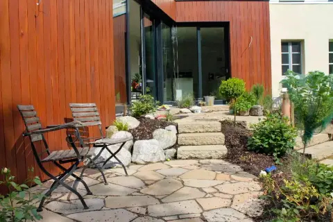 Fertiger Garten: Sitzplatz mit Natursteinbelag am Haus